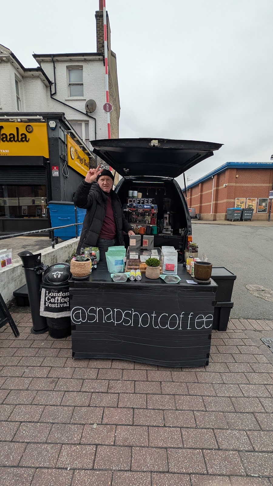 The Snapshot Coffee van set up on its pavement pitch with a stocked stall table in front
